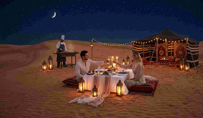 A couple toasts during a romantic private dune dinner in Abu Dhabi under the stars, with a personal chef and Bedouin tent, representing the experience for which one might search for the Romantic Private Dune Dinner Abu Dhabi Price.